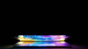 Stylised photograph of a laptop opening and coloured light emerging