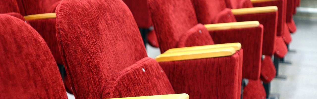 Lecture - red chairs awaiting bottoms