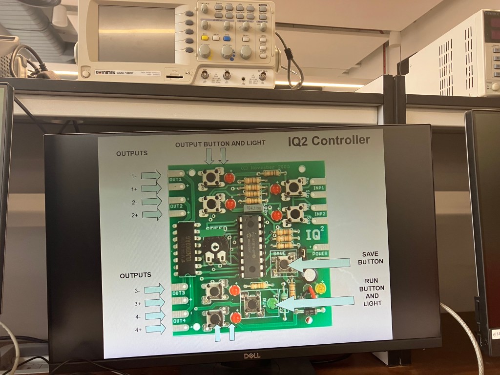 A photograph of a computer screen showing the type of controller that will be used. It's a square green printed circuit board with resistors, buttons, chips and connections as well as indicator lights to tell you if something is happening as expected.